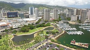 Cinematic 4K aerial drone footage of high-rise hotels, boat harbor, marina, Ala Moana Center on the shore of Ala Moana, near Honolulu on Oahu island in Hawaii known for its popular surfing and beaches
