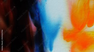 Transparent space liquid is filled with drops of red, blue, yellow and green paint.