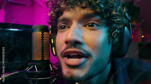 Arabian Indian Latino American man streamer blogger vlogger screaming amazing microphone studio computer cyberspace shouting technology audience influence gamer player male guy talk headphones awesome