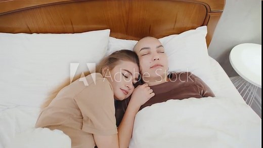 Two lesbians sleep peacefully in bed, cuddling closely, enjoying a serene and intimate moment together, wrapped in each other embrace.