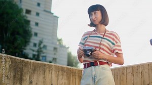 young girl with a camera. the photographer sets up the camera and takes a shot. Stylish girl with a film camera. film camera close up. adventures and travel.