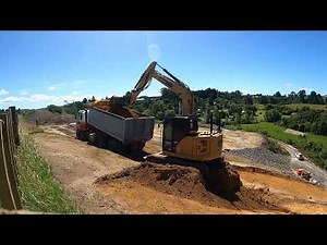 cat 310 excavator cutting batter and loading out 6 wheeler truck