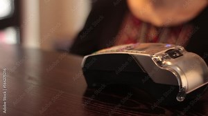 Hand Swiping Credit Card On POS Terminal. Man’s hand pushing the button and swipe credit card payment on pos terminal standing on wooden desk. Transactions at the credit card terminal. Stock Video