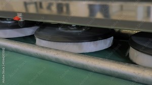 Fully automatic carpet washing machine with moving round roller brushes is operating in demonstration mode at the chemical cleaning exhibition, trade show - close up view