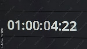 Time code running in a video editor software. Digital clock timer panel. Close up.