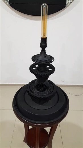 Black Tower Luis Argumedo Escultura Funcional 60 x 40cm Esta lámpara escultórica surge del alma metálica de antiguos vehículos: la base es una tapa de filtro de aire de los años 80s, acompañada por un diferencial automotriz, engranes y piezas industriales recicladas. Cada elemento conserva su historia de movimiento y fuerza, ahora transformada en una obra única donde el pasado mecánico cobra vida con elegancia y carácter. 💀♻️