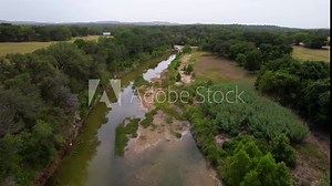 Aerial footage of the Blanco River in Blanco Texas in the Texas Hill Country. Camera is heading west and it high above the river.