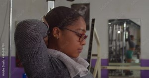 Weight lifter tying her hair before an intense workout at the gym