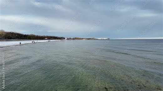 Winter coastal scenery at the Baltic Sea in Boltenhagen, Germany, filmed in January. The video shows a snowy beach with people walking along the shoreline under a dramatic winter sky.