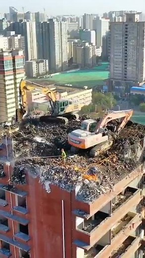 Amazing excavator demolishing the high building from the top
