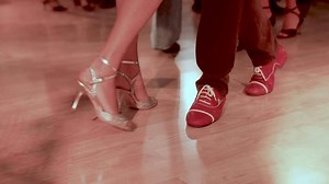 Couples dancing traditional latin argentinian dance milonga in the ballroom, tango salsa bachata kizomba lesson in red and purple lights, evening dance school class festival, performance rehearsal