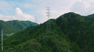 険しい山の上に建設された鉄塔・送電線・電線路・高圧線 空撮