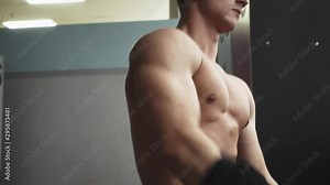 Fit young man changing clothes in changing room of gym