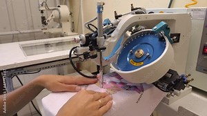 The process of applying rhinestones to clothes using an industrial machine.
