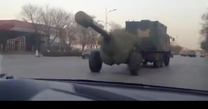 Chinese military truck tows giant rubber gun down the street, induces giggles 【Video】