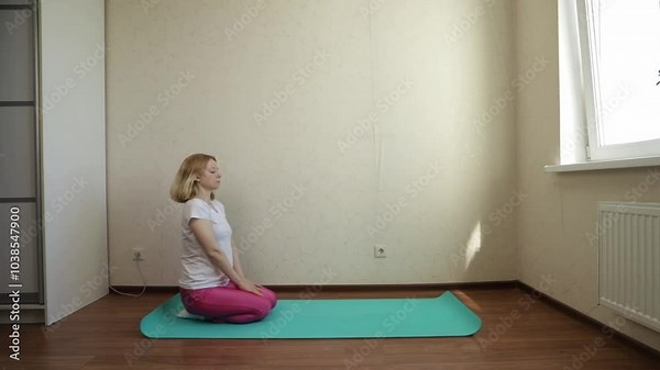 Woman doing yoga at home, engaging in peaceful meditation, enhancing mental and physical energy.
