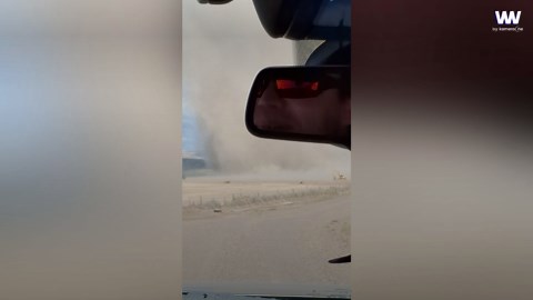 Family drives through enormous dust devil