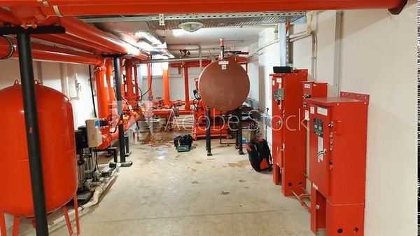 Industrial fire pump room with red distribution pipes and water suppression system