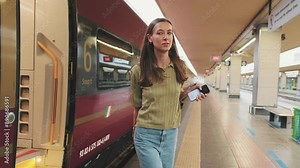 Young woman gets off the train at the railway station