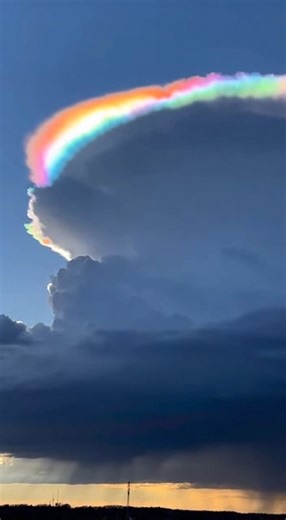 "This can't be real." 🤯 That was our exact reaction too! A pileus cloud with cloud iridescence ignites the sky as sunlight diffracts through tiny, uniform droplets, splitting into vivid spectral colors. Nature’s own prism—no filters, no edits—just physics putting on a show. ☁️✨ | Otherworld Earth