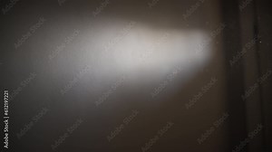 Sunlight from the window shining on the wall revealing dust particles in the air. Slow motion.