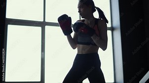 Fitness woman in boxing gloves training at home