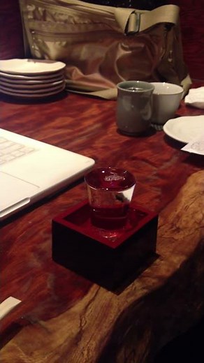 pouring sake into cup and masu (traditional japanese cup)