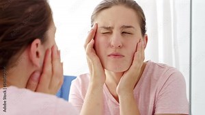 Beautiful 20s woman looking in mirror and checking her face skin condition. Concept of female aging, skin issues, facial treatment and care