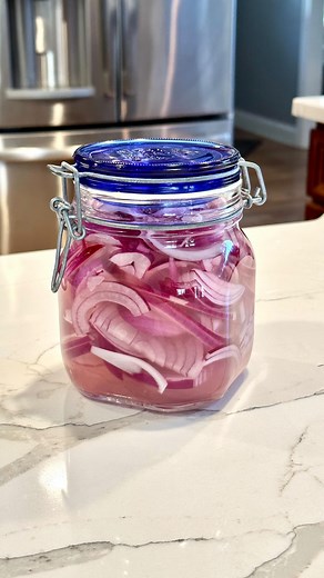 Pickled red onions are an absolute staple in our fridge! We love putting them on burgers, tacos, salads, and honestly sometimes just eating them on their own. To make them, just thinly slice your red onions in these half moon shapes, put them in a jar with some pickling salt (or kosher salt). Fill the jar with half white vinegar, half boiling water. Close the jar and give it a good shake, and refrigerate. They’ll be ready to eat in as little as 30 minutes! #pickledonions #pickledveggies #pickled