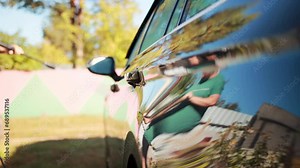 Washing a car with a high pressure washer. Washing wheels and rims in nature. Slow motion