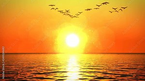 Flock of birds flying over ocean surface heading towards orange sunset