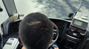 Bus driver head, defocussed coach controls, driving on the road; overhead view.