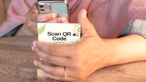 clip-4016549585-woman-scanning-qr-code-menu-smartphone-restaurant