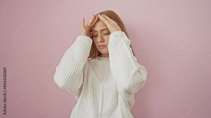 Distressed young redhead woman in sweater gripping head, suffering migraine pain from stress, standing isolated over pink background
