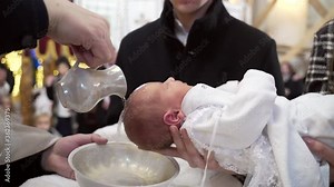 Newborn baby baptism in Holy water. Baptism in the font. Sacrament of baptism. Child and God. Christening candle Holy water font. The priest baptize. in the church