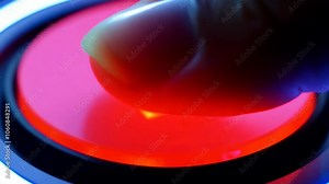 Close-up of a finger pressing a red, illuminated button, symbolizing decision-making, power, and modern technology in a dark setting.