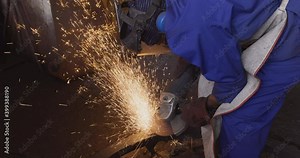 Factory worker using a grinder to grind off rough edges on a steel part that was cast at a foundry
