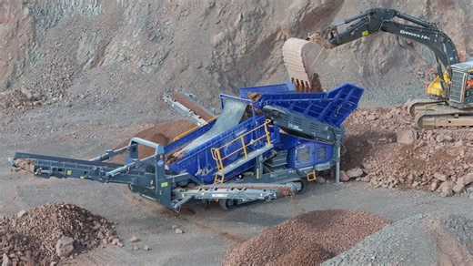 Massive excavator loads rock into a powerful screening machine