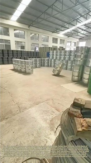 Rolling Barrels: Warehouse Worker Tilts Metal Drum To Curve Its Path Into Stacked Storage Gap