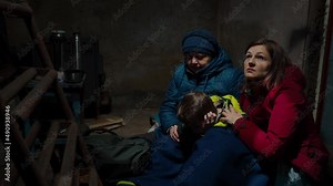 A scared family two women and a child hiding from danger in the cellar