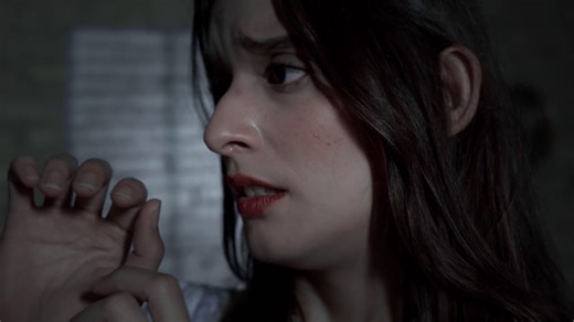 Woman in shock holds her head in dark room - Free Stock Video