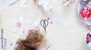 Flat lay. Step by step. Mother and daughter making unicorn craft from paper foam.