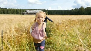 Little girls running cross the wheat field. Happy kids playing on wheat fild. Slow motion