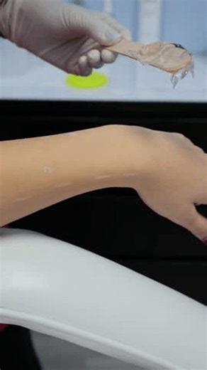 clip-3957682375-esthetician-applying-wax-woman