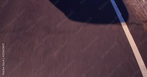 Close up of trailing car shadow driving on winding mountain road