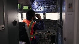 Male engineer checking the instrument panel in the airplane cockpit