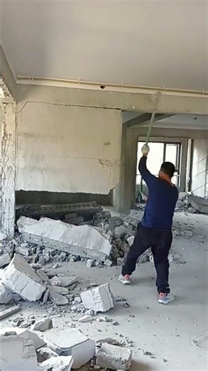 Interior Demolition: Worker Manually Tearing Down a Wall