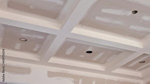 Finishing putty on drywall with a spatula the house on ceiling and wall