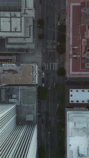 Slow Aerial Drone View of City Street with Skyscraper Rooftops and Road traffic, Birds Eye Overhead