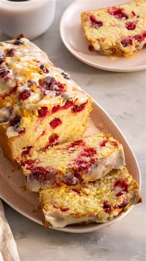 This soft and zingy Orange Cranberry Bread is packed with flavor and so lovely for snacking. Topped with an orange glaze and filled to the brim with flavor it’s an easy recipe you’ll love making and sharing! Recipe on the blog 👉 link in bio👈 #preppykitchen #baker #recipevideo | Preppy Kitchen